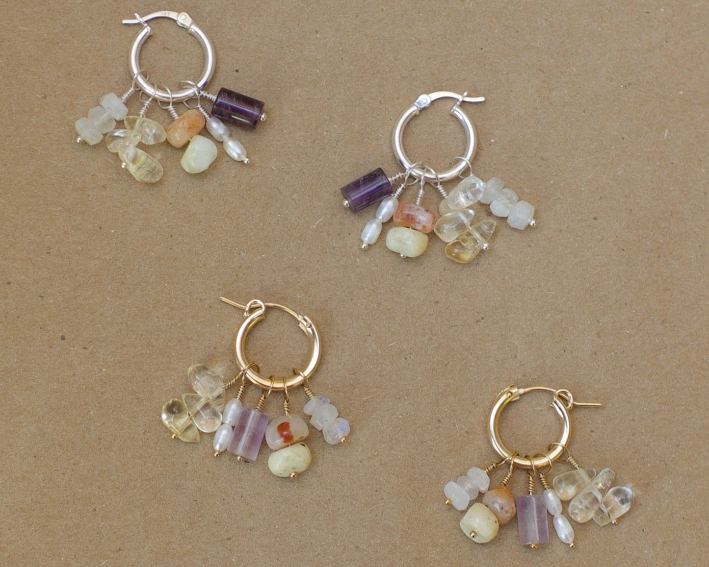 Set of four hoop earrings with bead charms on a brown background